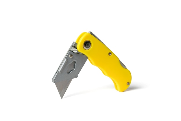 Cuchillo plegable amarillo para cortar aislado sobre un fondo blanco Herramienta de corte manual