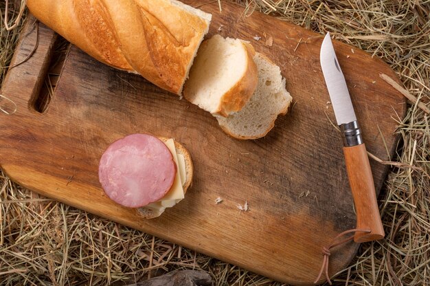 Cuchillo plegable francés y sándwich de salchichas Un cuchillo de cocina plegable y un sándwich casero Vista desde arriba