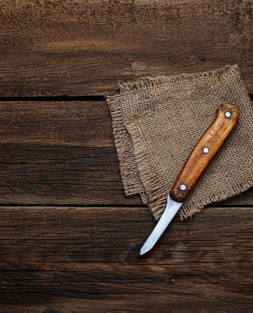 Cuchillo y servilleta de succión sobre fondo de madera.