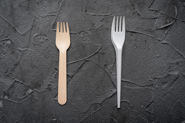 Cuchillo y tenedor de madera sobre el fondo negro Concepto ecológico zerowaste Vista superior con espacio para texto Espacio de copia