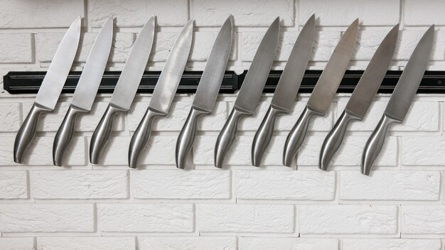 Cuchillos de cocina en pared blanca