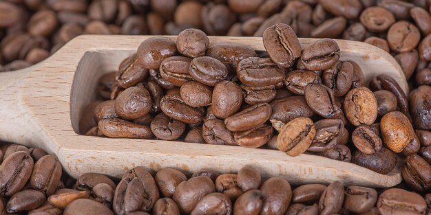 Foto cuchinha de madeira com café e grãos de café no fundo café como fundo