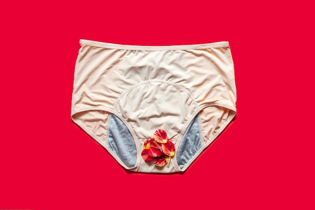 Cuecas menstruais reutilizáveis com pétalas de rosa em fundo vermelho Cuecas menstruais absorventes e acessíveis para absorver o fluido menstrual