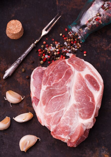 Cuello de bistec de cerdo crudo sobre un fondo oscuro