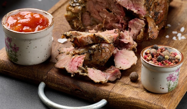 Cuello de cerdo al horno con especias en una tabla de madera carne deliciosa y jugosa