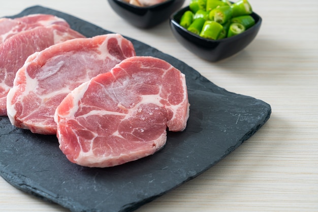 Cuello de cerdo fresco crudo o cuello de cerdo a bordo con ingredientes para marinado