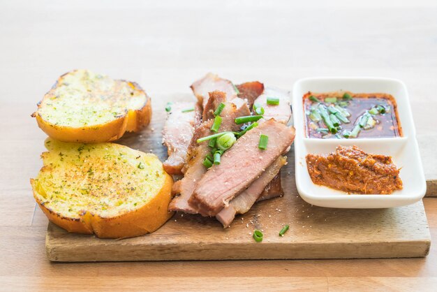 cuello de cerdo hervido con carbón y pan de ajo