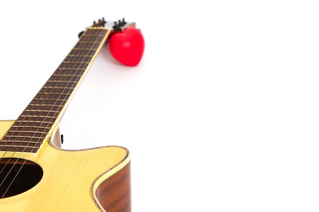 Cuello de guitarra acústica y corazón rojo sobre fondo blanco Concepto de amor y música