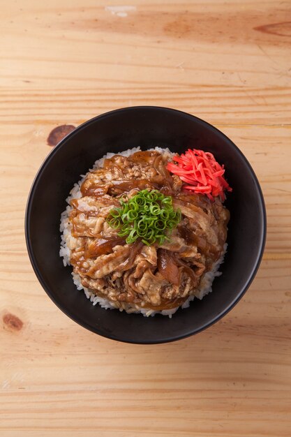 Cuenco de arroz de cerdo japonés sobre mesa de madera