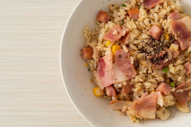 cuenco de arroz frito con tocino, jamón y pimientos negros