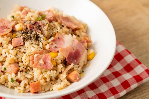 cuenco de arroz frito con tocino, jamón y pimientos negros