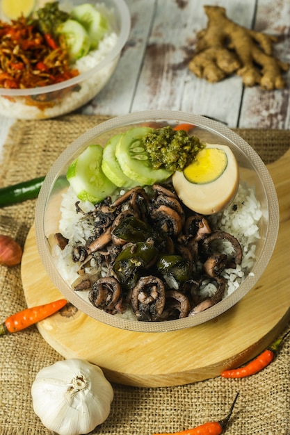 Cuenco de arroz de Indonesia con huevo y cobertura y verduras frescas