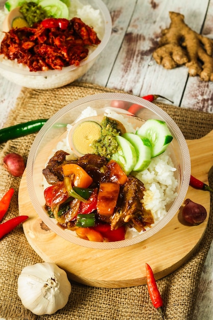 Cuenco de arroz de Indonesia con huevo y cobertura y verduras frescas