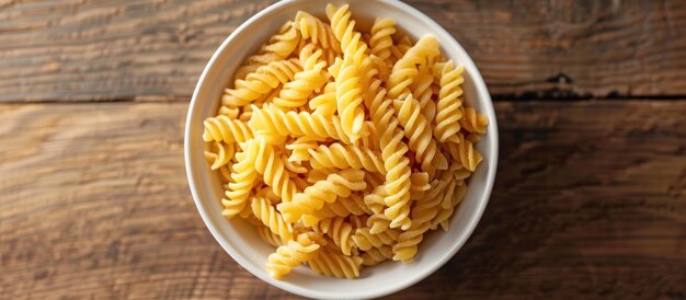 Un cuenco blanco lleno de pasta en una mesa de madera