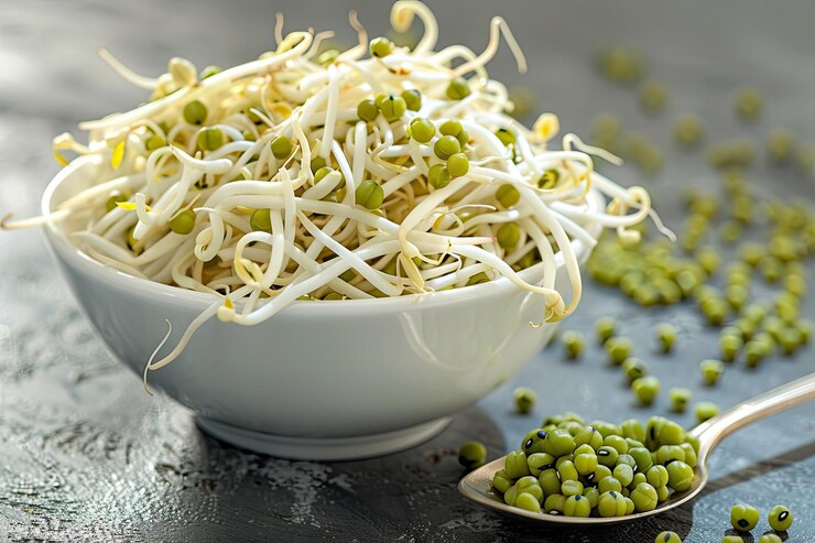 Un cuenco de brotes de frijoles mung frescos con algunos frijoles enteros esparcidos