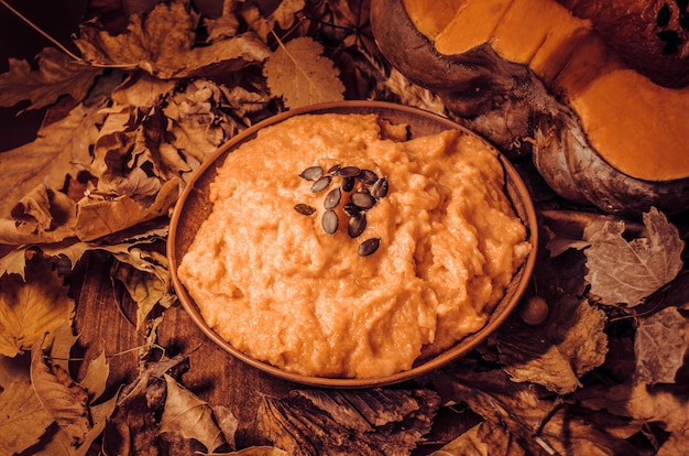 Cuenco de calabaza de otoño. Gachas de avena y calabazas de la calabaza en la tabla de madera.