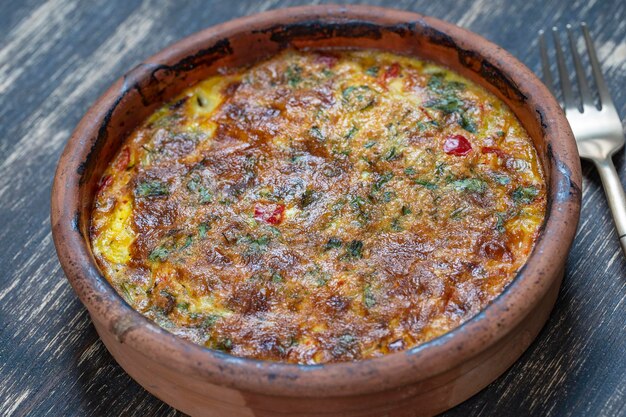 Cuenco de cerámica con frittata de verduras comida vegetariana simple Frittata con tomate pimiento cebolla y queso en la mesa de madera cerrar tortilla de huevo italiana