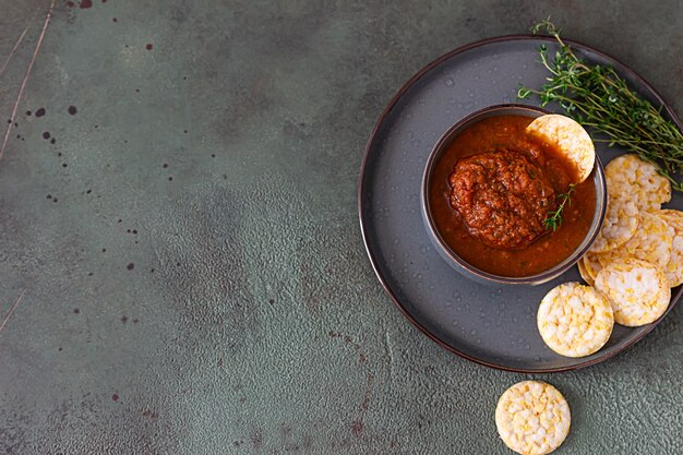 Cuenco de cerámica con salsa de tomate picante, totopos y tomillo. Concepto de comida mexicana.