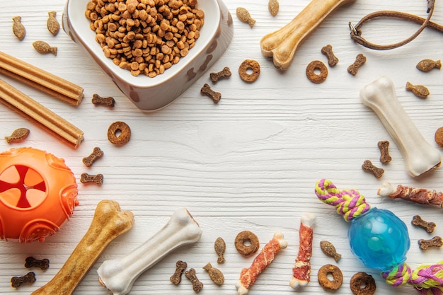 Foto un cuenco con comida para perros, golosinas y juguetes para perros en un piso de madera concepto de comida saludable para perros