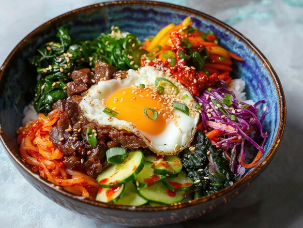Cuenco coreano de Bibimbap con verduras de carne de res y un huevo frito