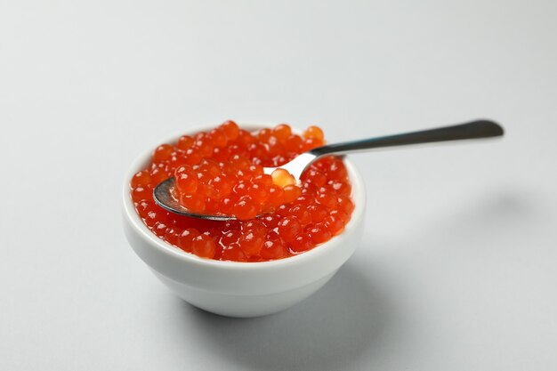 Cuenco y cuchara con caviar en gris