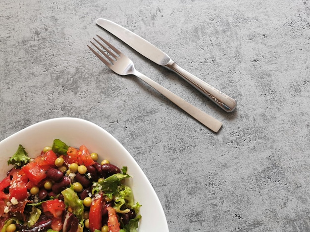 Cuenco de cuchillo y tenedor de ensalada de verduras sobre la mesa
