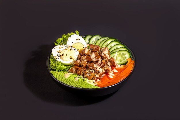 Foto cuenco de ensalada con carne de res, arroz, tomates, pepinos y huevo hervido de aguacate