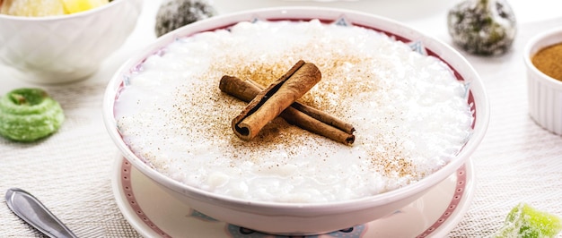 Cuenco grande con pudín de arroz dulce con canela y canela en polvo postre casero dulce típico de Brasil en las fiestas de junio