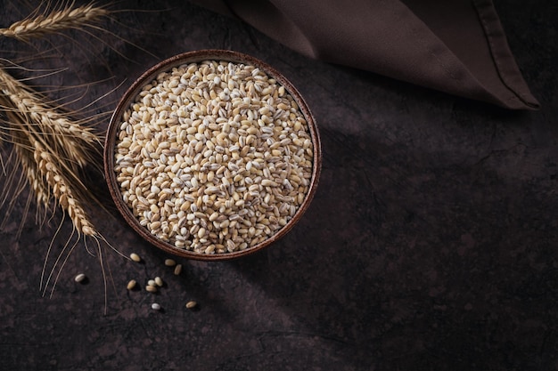 Cuenco de grano de cereal de cebada perlada rota seca cruda