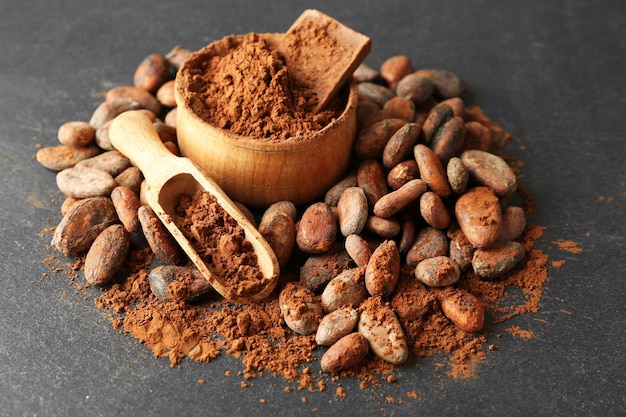 Cuenco con granos de cacao aromáticos y chocolate sobre fondo gris de cerca