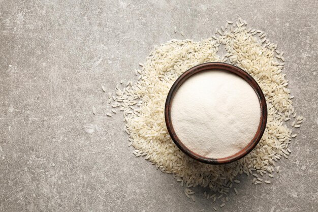 Un cuenco con harina de arroz sobre un fondo gris