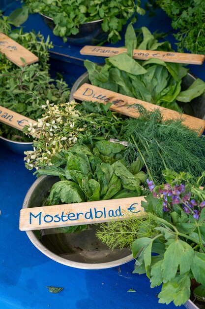 Un cuenco de hojas de mostaza frescas en una barraca de mercado vertical