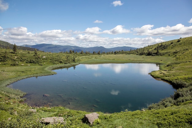 El cuenco de un lago de montaña rodeado de bosques y picos