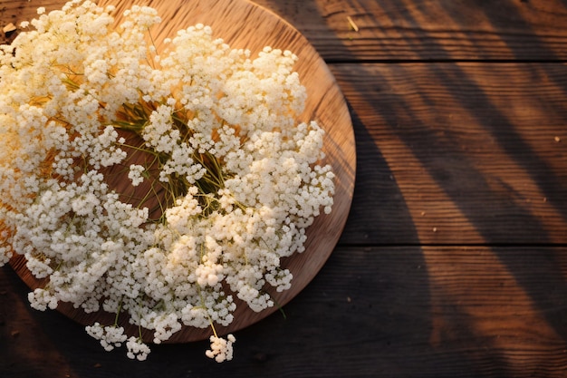 un cuenco de madera con flores blancas sobre una mesa de madera