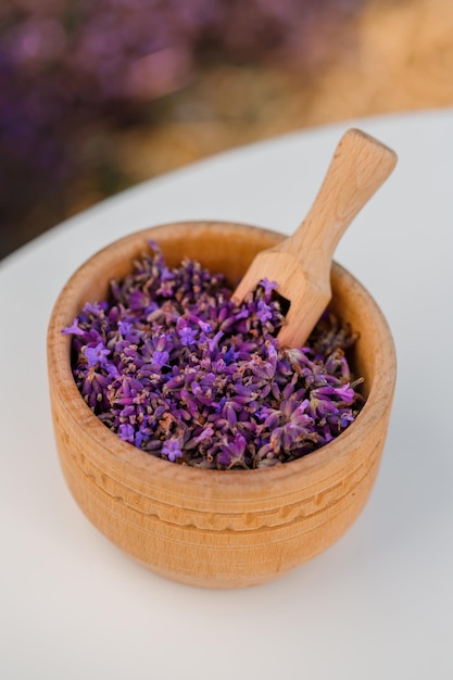 Cuenco de madera con lavanda seca en el fondo del campo Bebida de té de hierbas de flores Ingrediente de medicina de aromaterapia Bebida calmante