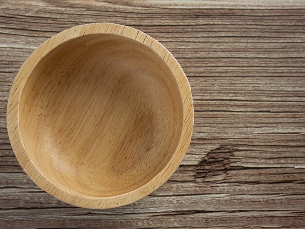 El cuenco de madera en la mesa de madera para alimentos o concepto de cocina