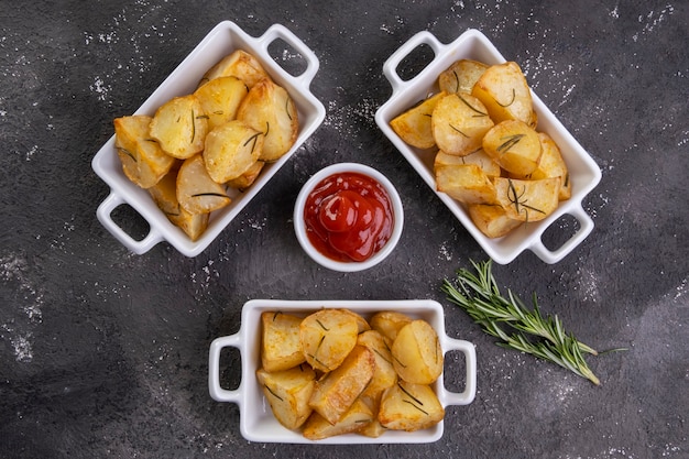 Cuenco de patatas rústicas fritas y asadas con romero.