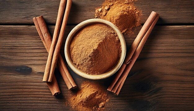 Un cuenco de polvo de canela y palos en una mesa de madera.