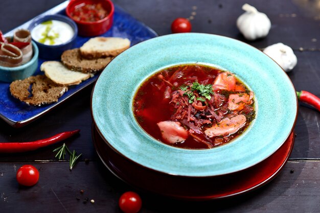 Cuenco de sopa roja nacional ucraniana o rusa de la verdura y de la carne. Plato tradicional eslavo con remolacha, repollo, tomate