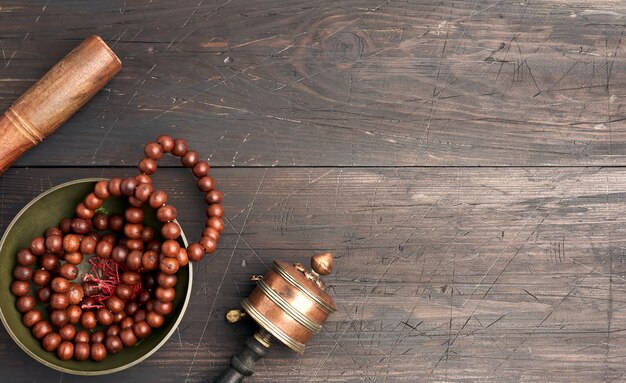 Cuenco tibetano de cobre con un badajo de madera sobre una mesa de madera marrón