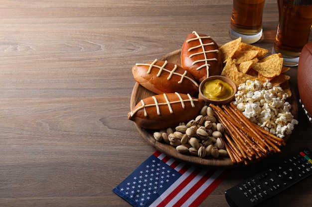 Un cuenco con varios snacks, un mando a distancia y una bandera americana.