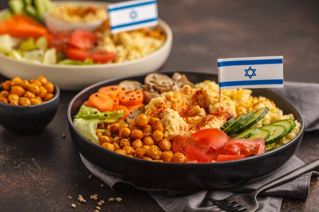 Cuencos de buda con verduras, champiñones, bulgur, hummus y garbanzos al horno. Concepto de comida israelí.