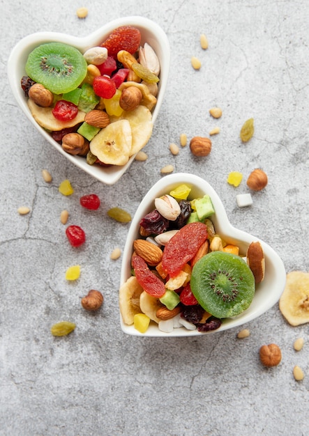 Cuencos con diversos frutos secos y nueces sobre una superficie de hormigón gris