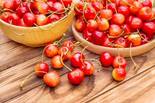 Cuencos de madera con cerezas sobre la mesa.