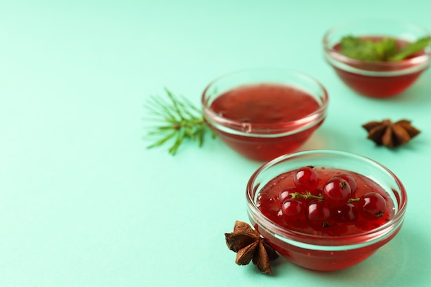 Cuencos con salsa de arándanos sobre fondo de menta