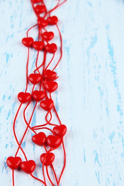 Cuentas en forma de corazón en cadena sobre fondo de madera