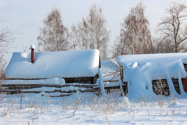 Cuento de hadas de invierno en el pueblo con techos cubiertos de nieve, pozos