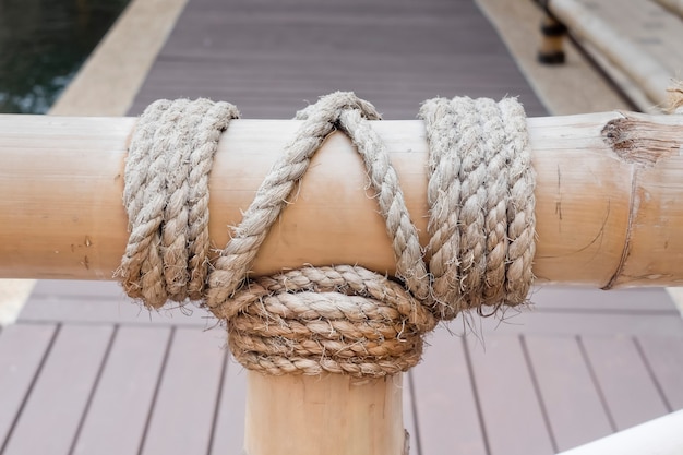 Cuerda atada nudo en madera de bambú en el charco de pescado