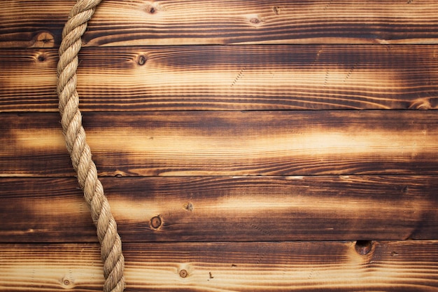 Cuerda de barco en el fondo de madera, textura de tablero de tablón