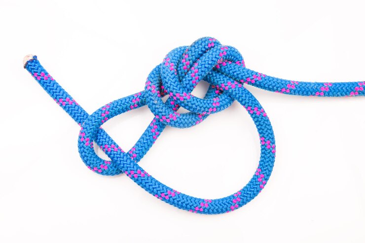 Foto cuerda de color duradero para equipo de escalada en un nudo de fondo blanco de cable trenzado para turismo y viajes